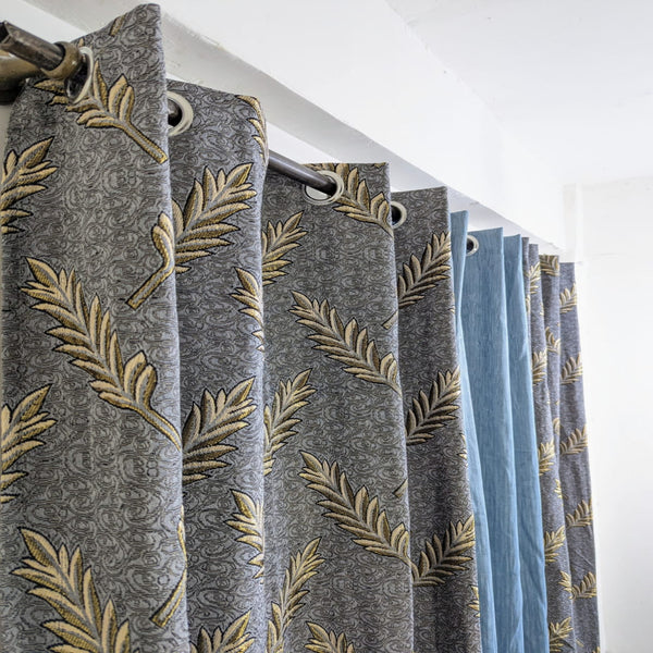 Curtains with leaf pattern and blue color swatch on a white background