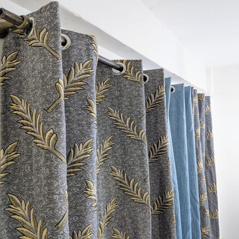 Curtains with leaf pattern and blue color swatch on a white background
